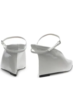 Glossy leather mules with wedge heel and strap