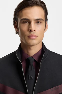 Jacquard-woven tie with metallic stacked-logo trim
