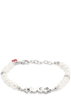 Pearl cuff with metal logo plaque