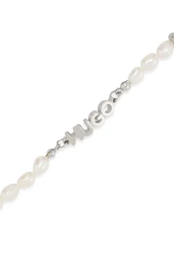 Pearl cuff with metal logo plaque