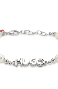 Pearl cuff with metal logo plaque