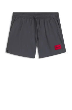 Quick-drying swim shorts with red logo label