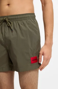 Quick-drying swim shorts with red logo label