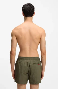 Quick-drying swim shorts with red logo label