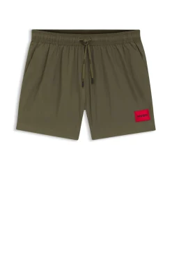 Quick-drying swim shorts with red logo label