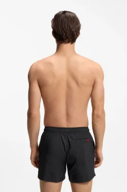 Quick-drying swim shorts with red logo label