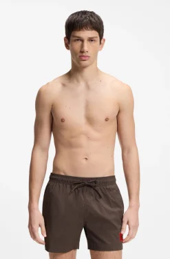 Quick-drying swim shorts with red logo label