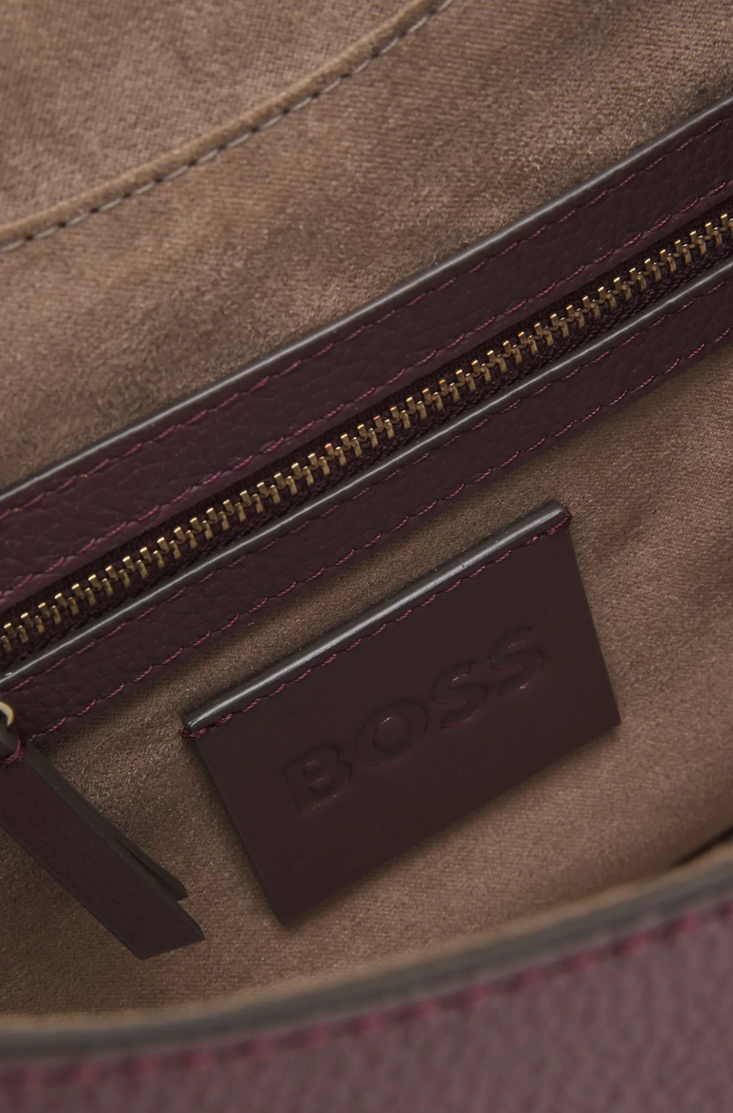 Shoulder bag in grained leather with logo plate